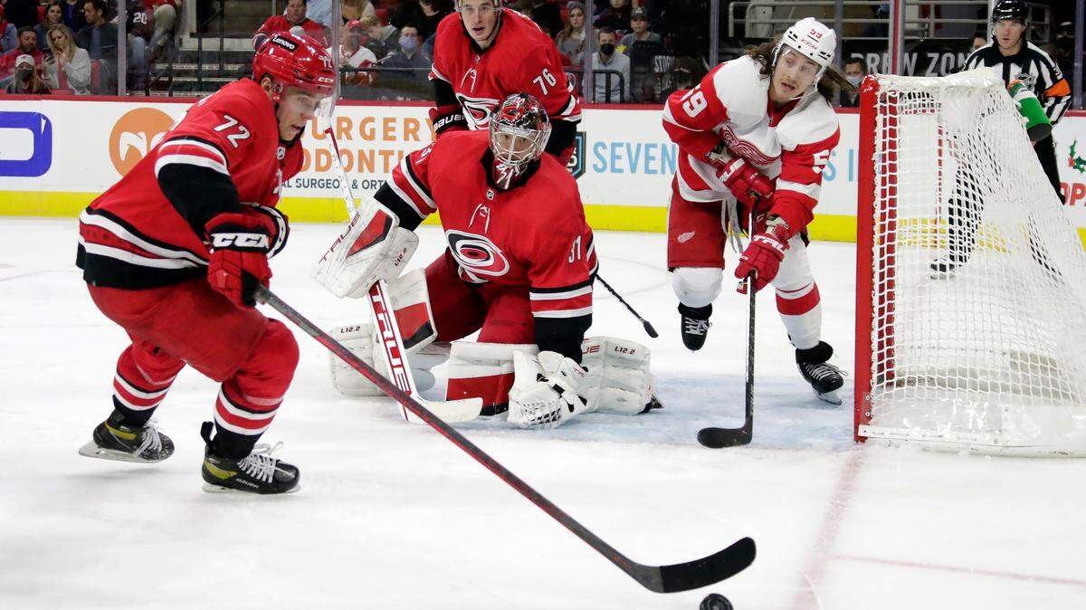 Carolina Hurricanes center Jack Drury (72), goaltender Frederik Andersen (31) and defenseman Brady Skjei (76) defend the net against Detroit Red Wings left wing Tyler Bertuzzi (59) during the third period of an NHL hockey game Thursday, Dec. 16, 2021, in Raleigh, N.C. (AP Photo/Chris Seward)