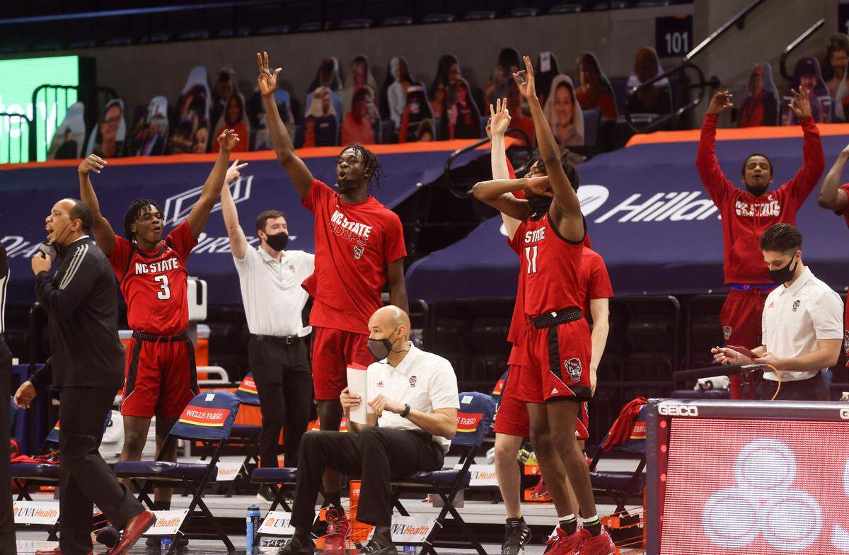 North Carolina State players react to a basket during the game Wednesday in Charlottesville, Va. North Carolina State defeated Virginia 68-61.