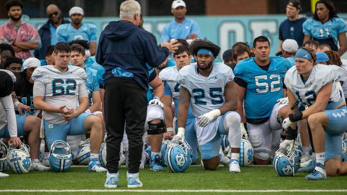 North Carolina senior lineman Kaimon Rucker (25) listens to coach Mack Brown following practice on Saturday, March 25, 2023 at Kenan Stadium in Chapel Hill. N.C.