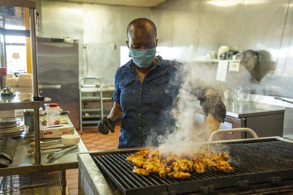 Zweli Williams cooks chicken during lunchtime at Zweli’s, owned by her and her husband Leonardo Williams, on Tuesday, Apr. 14, 2020, in Durham, N.C. They have lot 80 percent of their business during the coronavirus pandemic and reduce their employees from 18 to nine, Leonardo Williams said.