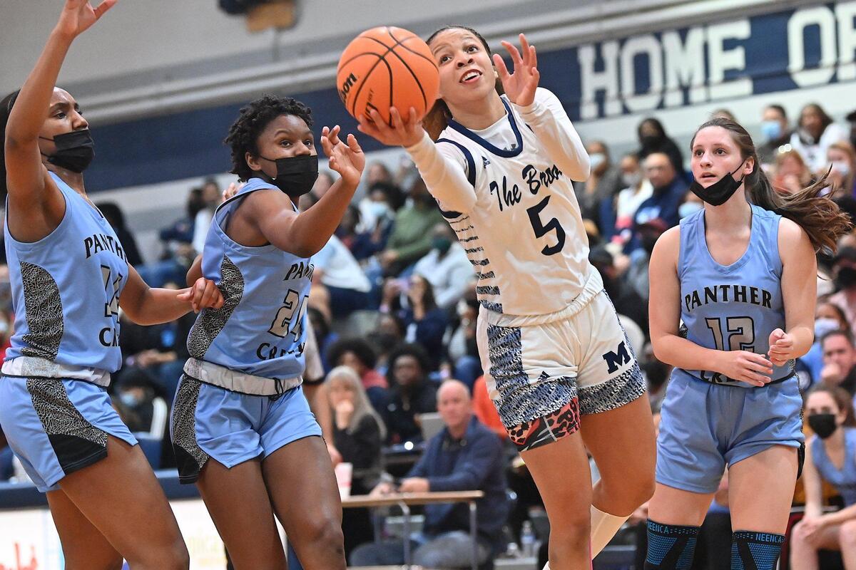 Millbrook’s Reychel Douglas (9) leans forward for the layup between Panther Creek’s Kirstin Smalls (24) and Autumn Fritz (12) . The Millbrook Wildcats and the Panther Creek Catamounts met in a NCHSAA 4A fourth round game in Raleigh, N.C. on March 1, 2022.
