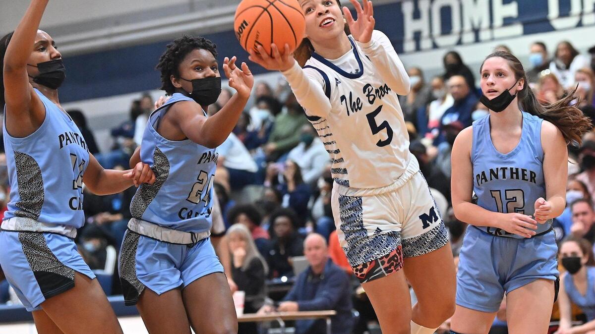 Millbrook’s Reychel Douglas (9) leans forward for the layup between Panther Creek’s Kirstin Smalls (24) and Autumn Fritz (12) . The Millbrook Wildcats and the Panther Creek Catamounts met in a NCHSAA 4A fourth round game in Raleigh, N.C. on March 1, 2022.
