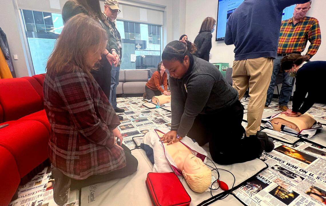 Bertice Jones with Wake County EMS, right, demonstrates to Dawn Baumgartner Vaughan how to do chest compressions during CPR training in the newsroom in Raleigh on Tuesday, Jan. 17, 2023.