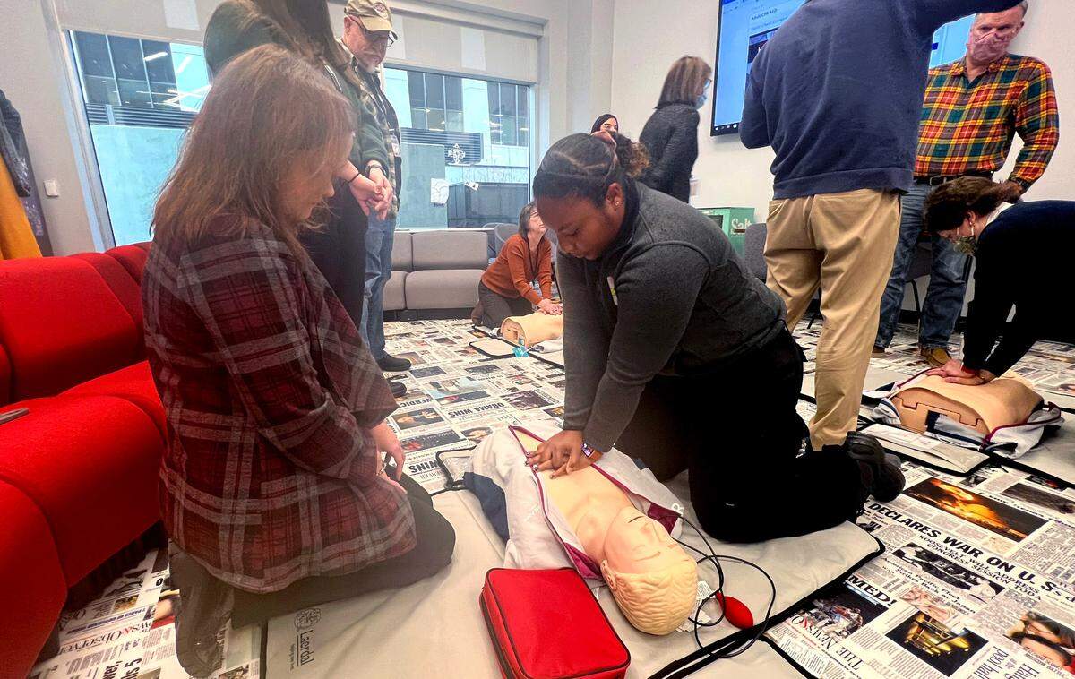 Bertice Jones with Wake County EMS, right, demonstrates to Dawn Baumgartner Vaughan how to do chest compressions during CPR training in the newsroom in Raleigh on Tuesday, Jan. 17, 2023.