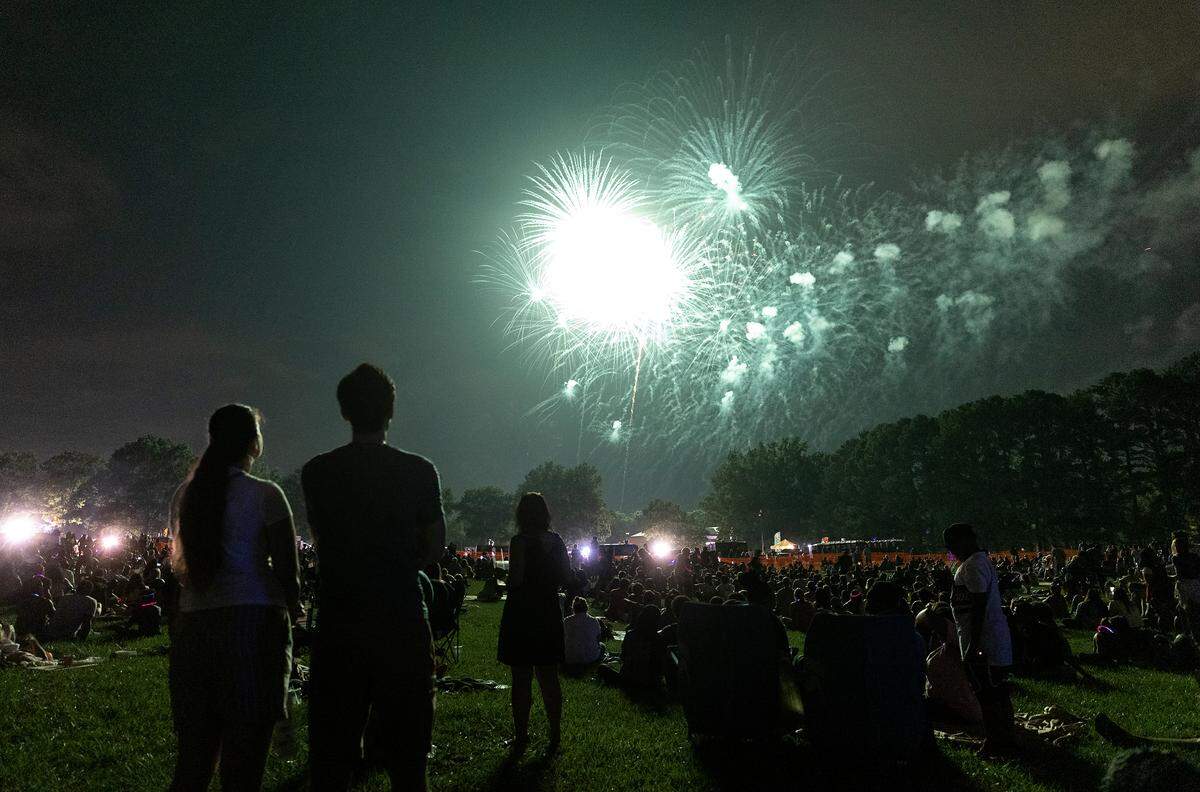 Crowds watch a fireworks display during an Independence Day celebration at Dorothea Dix Park on Tuesday, July 4, 2023, in Raleigh, N.C.