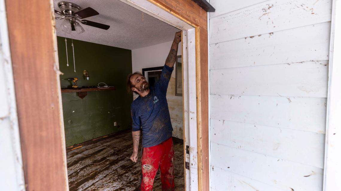 Brandon Patterson points to the water line inside a flooded home in Clyde on Saturday, Sept. 28, 2024 after massive flooding damaged dozens of homes and businesses. The remnants of Hurricane Helene caused widespread flooding, downed trees, and power outages in western North Carolina.