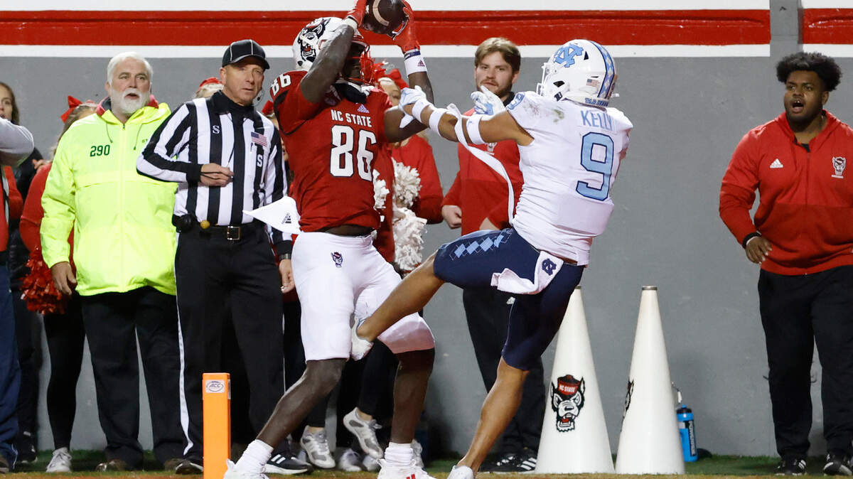 N.C. State wide receiver Emeka Emezie (86) makes the game-winning touchdown reception as North Carolina defensive back Cam’Ron Kelly (9) defends late in the second half of N.C. State’s 34-30 victory over UNC at Carter-Finley Stadium on Nov. 26, 2021.