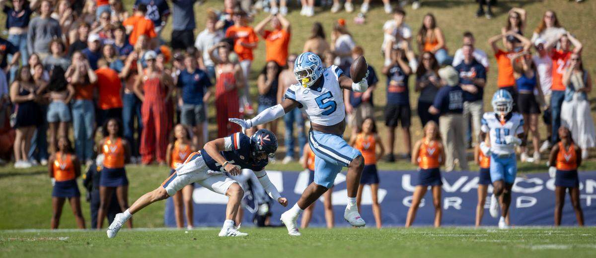 North Carolina defensive lineman Jahvaree Ritzie (5) stiff-arms Virginia quarterback Anthony Colandrea (10) after intercepting his pass, returning it 84-yards for a touchdown in the third quarter to give the Tar Heels’ a 38-6 lead on Saturday, October 26, 2024 at Scott Stadium in Charlottesville, Va.