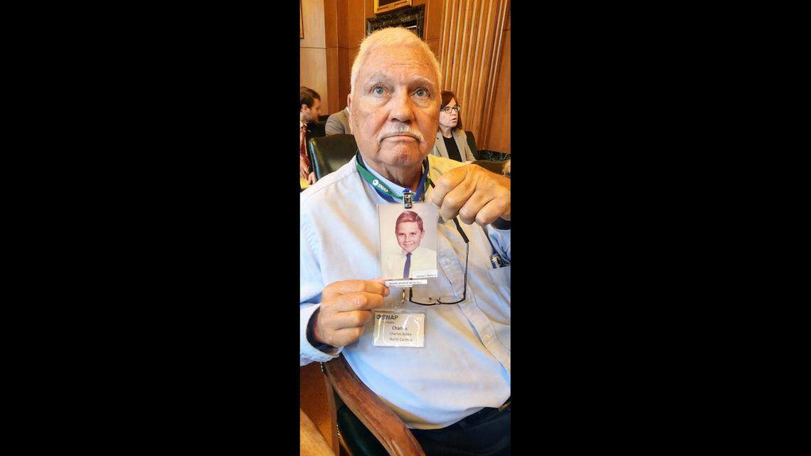 Charles Bailey, holding up a photo of himself when he was abused by a Catholic priest at 10-years-old, attended a North Carolina Supreme Court hearing on Wednesday, Sept. 18, 2024.