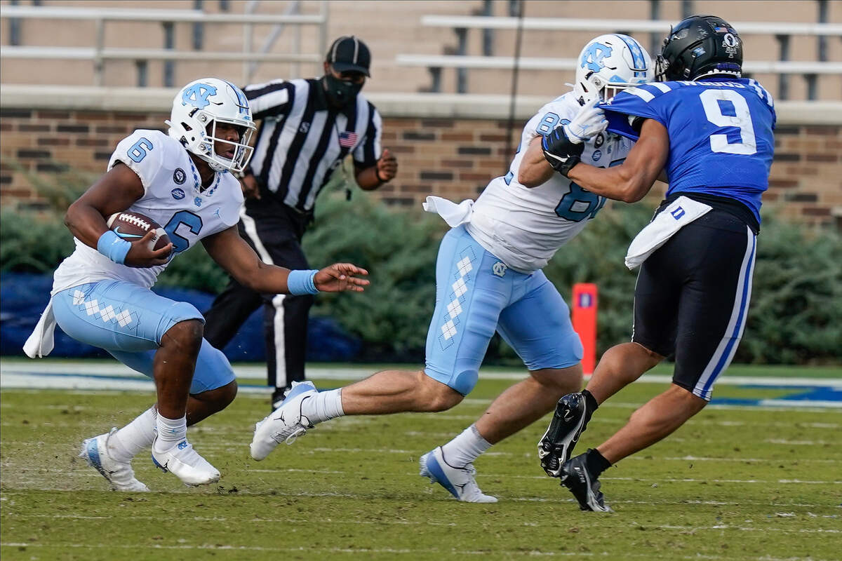 North Carolina Tar Heels quarterback Jacolby Criswell (6) follows the block of tight end Kendall Karr (82) against Duke Blue Devils safety J’Marick Woods (9) during the second half at Wallace Wade Stadium. 