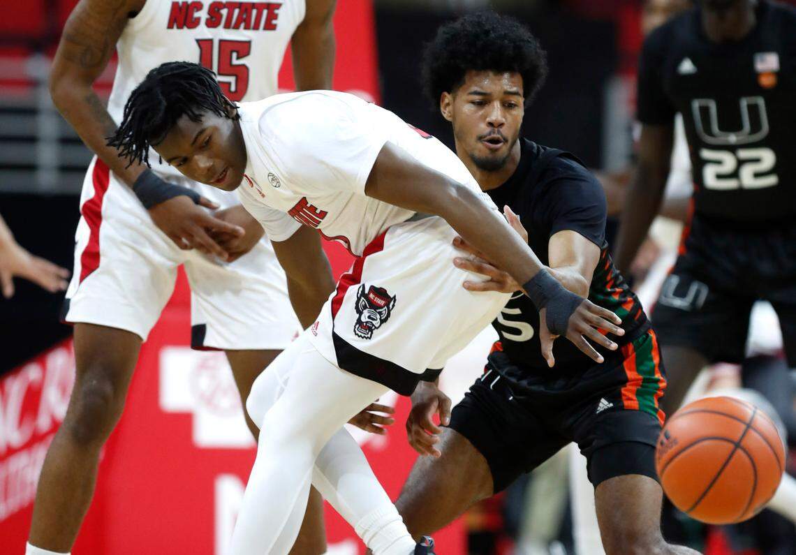Miami’s Harlond Beverly (5) steals the ball from N.C. State’s Cam Hayes (3) during the first half of N.C. State’s game against Miami at PNC Arena in Raleigh, N.C., Saturday, January 9, 2021.