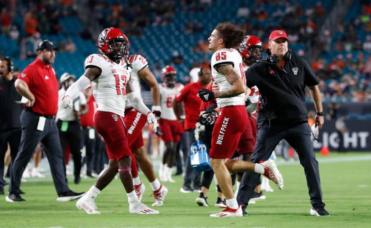 N.C. State wide receiver Anthony Smith (85) heads back to the sidelines after recovering a fumble during the second half of Miami’s 31-30 victory over N.C. State at Hard Rock Stadium in Miami Gardens, Fla. Saturday, Oct. 23, 2021. Because he lost his helmet before recovering the fumble, Smith was assessed a personal foul and the Wolfpack had to re-kick the punt.