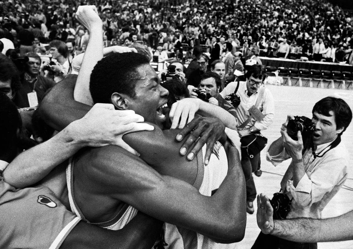 UNC center Sam Perkins celebrates with teammates on the floor of the Super Dome after the Tar Heels defeated Georgetown to win the 1982 National Championship.