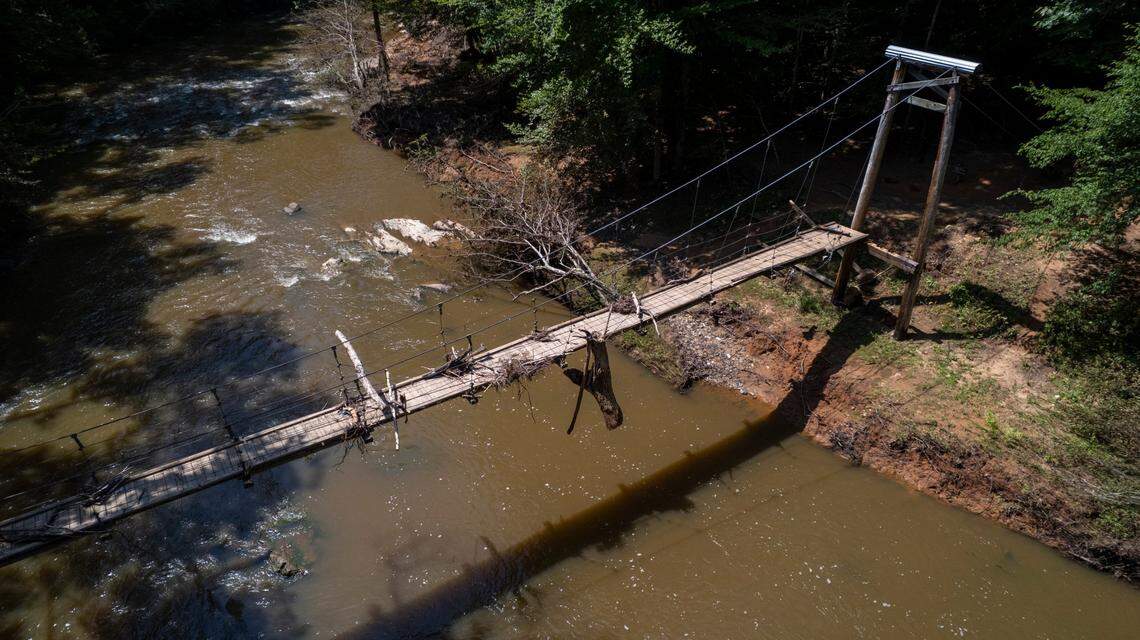 An aerial view of a flood-damaged pedestrian suspension bridge on Monday, July 21, 2025, as Eno River State Park remained closed due to flooding from Tropical Depression Chantal.