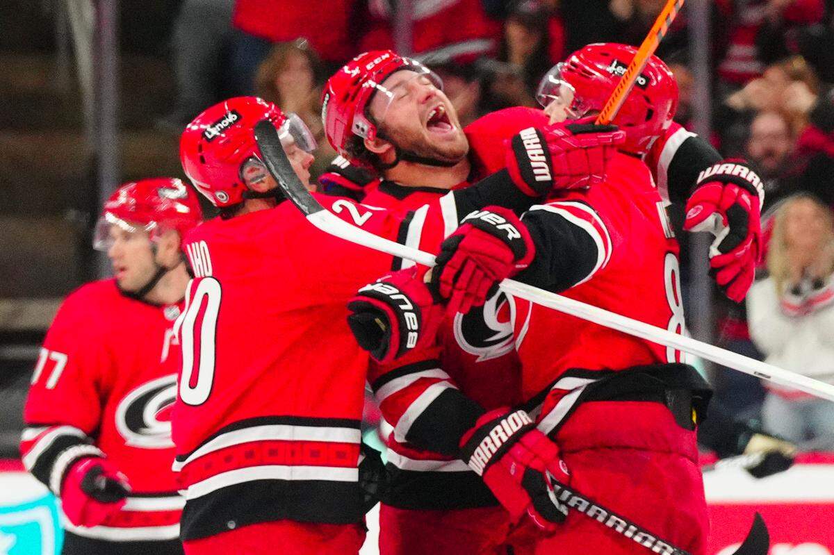 Carolina Hurricanes center Martin Necas (88) celebrates his game winning goal with left wing Brendan Lemieux (28) and center Sebastian Aho (20) against the Seattle Kraken in the overtime at PNC Arena.