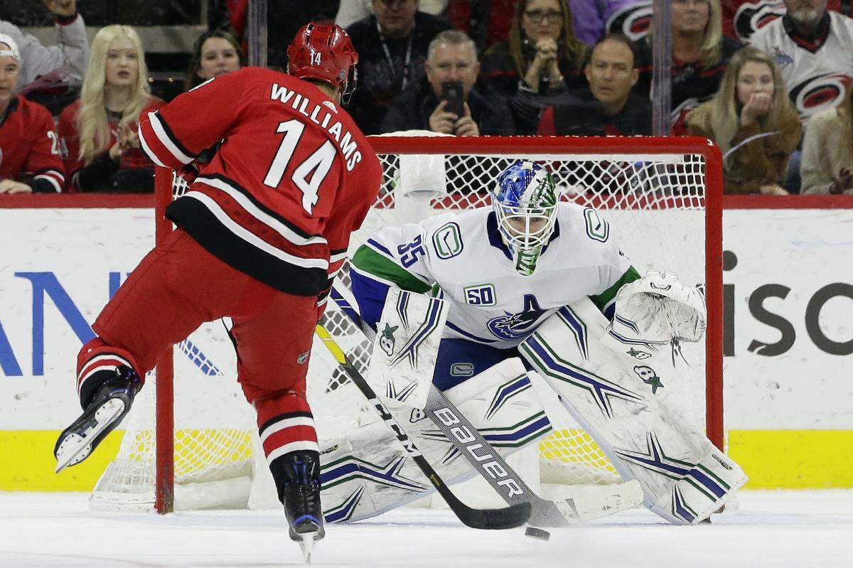 Carolina Hurricanes right wing Justin Williams (14) shoots the winning goal in a shootout against Vancouver Canucks goaltender Thatcher Demko (35) during an NHL hockey game in Raleigh, N.C., Sunday, Feb. 2, 2020. (AP Photo/Gerry Broome)