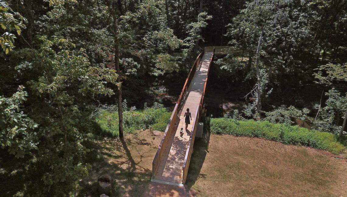 A woman walks her dog across the pedestrian bridge over the Eno River in Hillsborough. The bridge spans 95 feet over the Eno River and connects Hillsborough’s Riverwalk greenway to the Historic Occoneechee Speedway Trail.