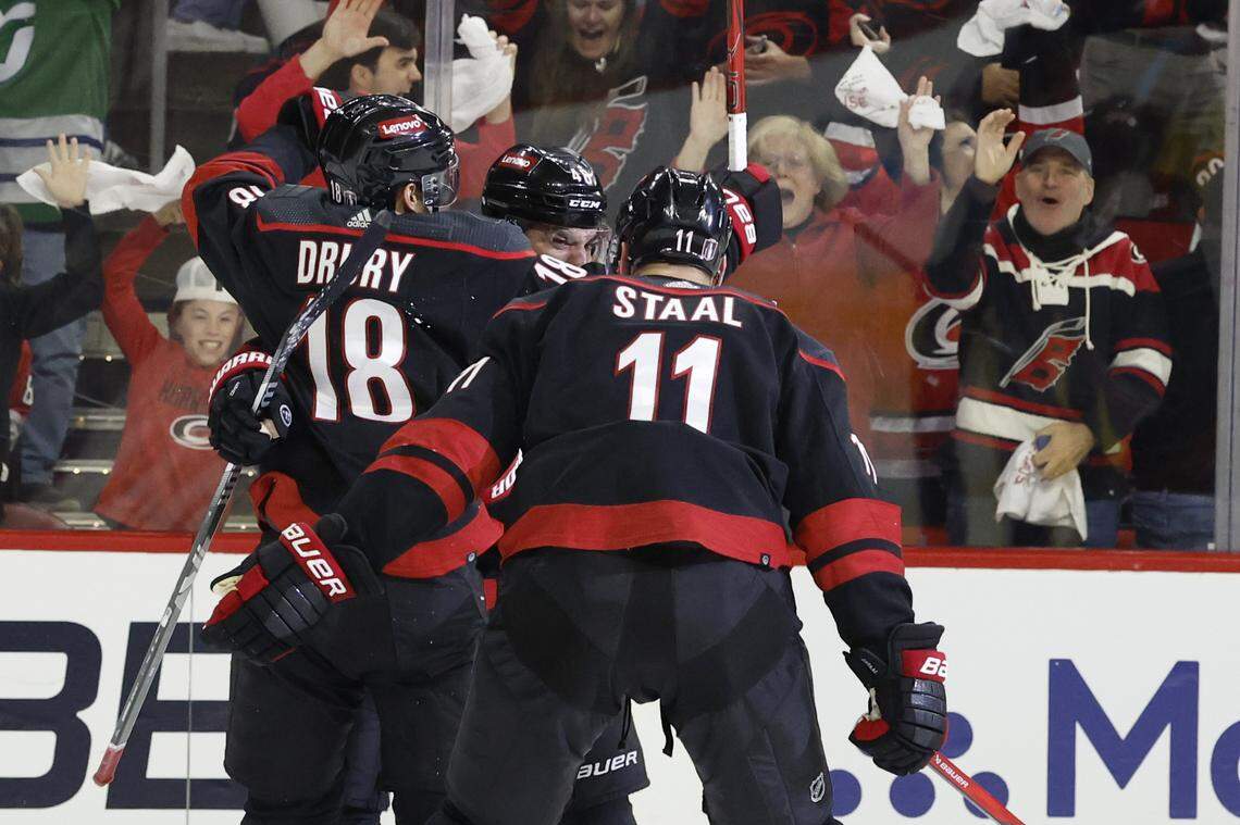 Carolina’s Jack Drury (18) and Jordan Staal (11) celebrate with Jordan Martinook (48) after Martinook scored to put the Canes up 4-3 during the third period of the Hurricanes’ 5-3 victory over the Islanders in the first round of the Stanley Cup playoffs at PNC Arena in Raleigh, N.C., Monday, April 22, 2024.