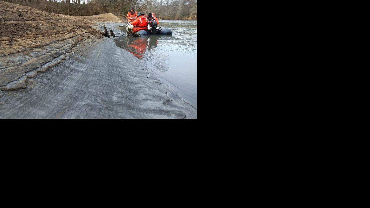 Tom Augspurger, left, with the USFWS, takes a core sample during February 8th reconnaissance of Dan River coal ash spill. From left, Tom Augspurger, USFWS, John Fridell, USFWS, Rick Smith, Duke Energy.
