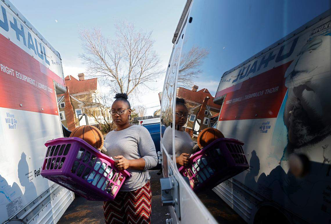 Portia Watson carries a basket of belongings to load in a U-Haul truck while moving out of her apartment in Durham, N.C. on Friday, Dec. 30, 2022. Watson says she received notice that her lease would not be renewed after she took in neighbors from the same complex.