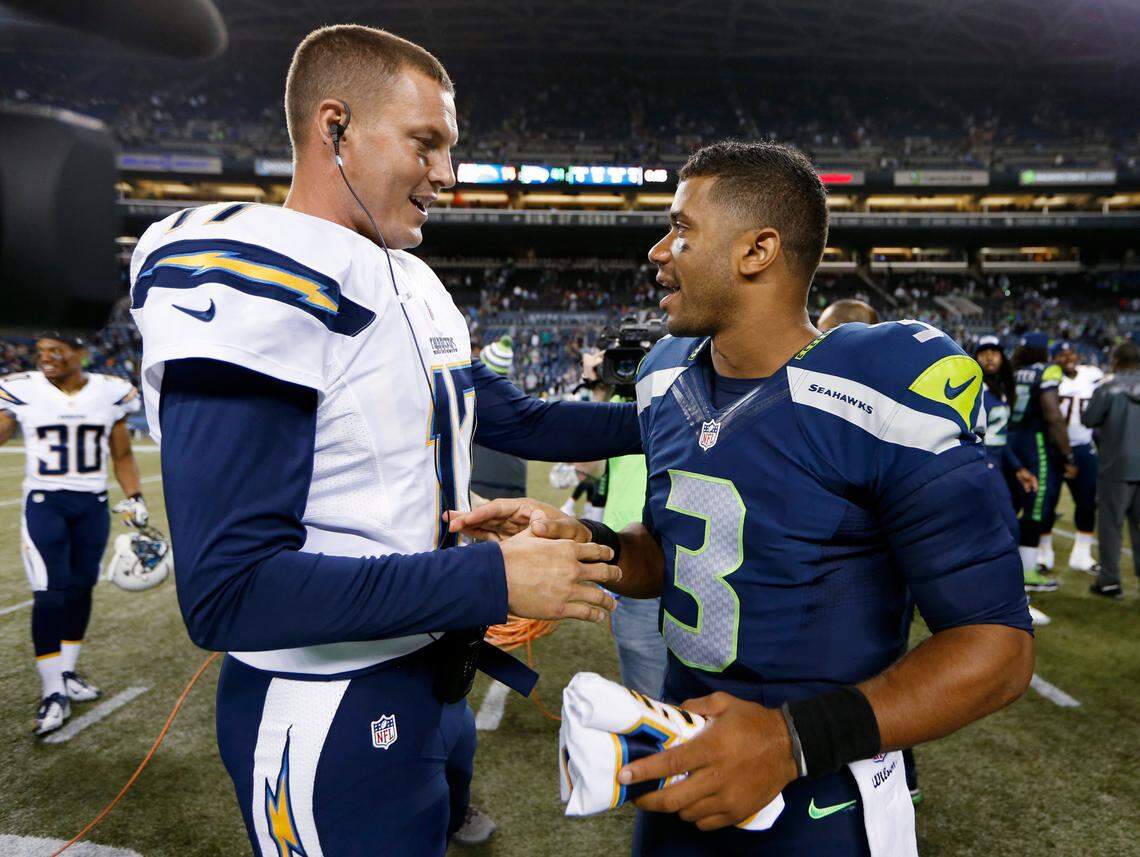 Seattle Seahawks quarterback Russell Wilson (3) visits with San Diego Chargers quarterback Philip Rivers after the Seahawks defeated the Chargers 41-14 in a preseason NFL football game, Friday, Aug. 15, 2014, in Seattle.