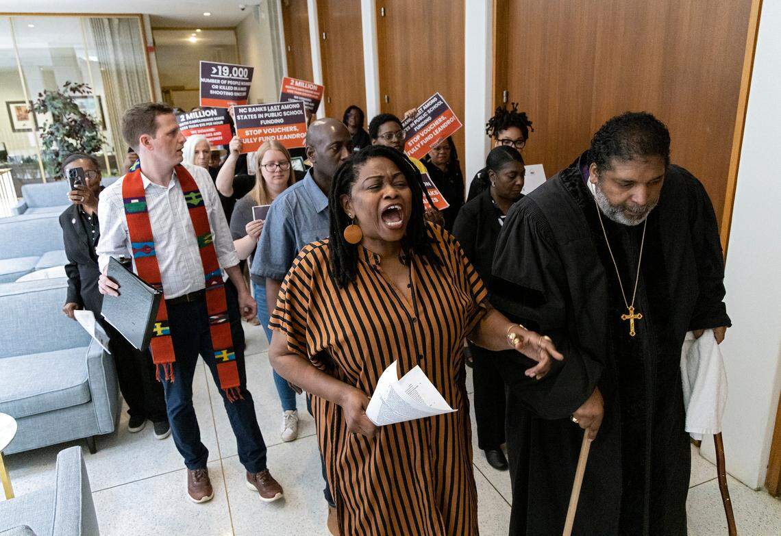 Yara Allen, center, sings while walking with Rev. William Barber as demonstrators protest against the state budget at the Legislative Building on Wednesday, May 24, 2023, in Raleigh, N.C.
