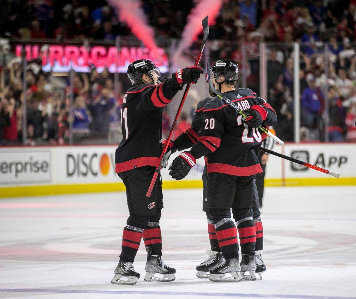 Carolina Hurricanes Jesper Fast (71) and Vincent Trocheck (16) embrace Sebastian Aho (20) after Ahos open net goal late in the third period to give the Hurricanes a 2-0 victory over the New York Rangers on Friday, May 20, 2022 during game two of the Stanley Cup second round at PNC Arena in Raleigh, N.C.