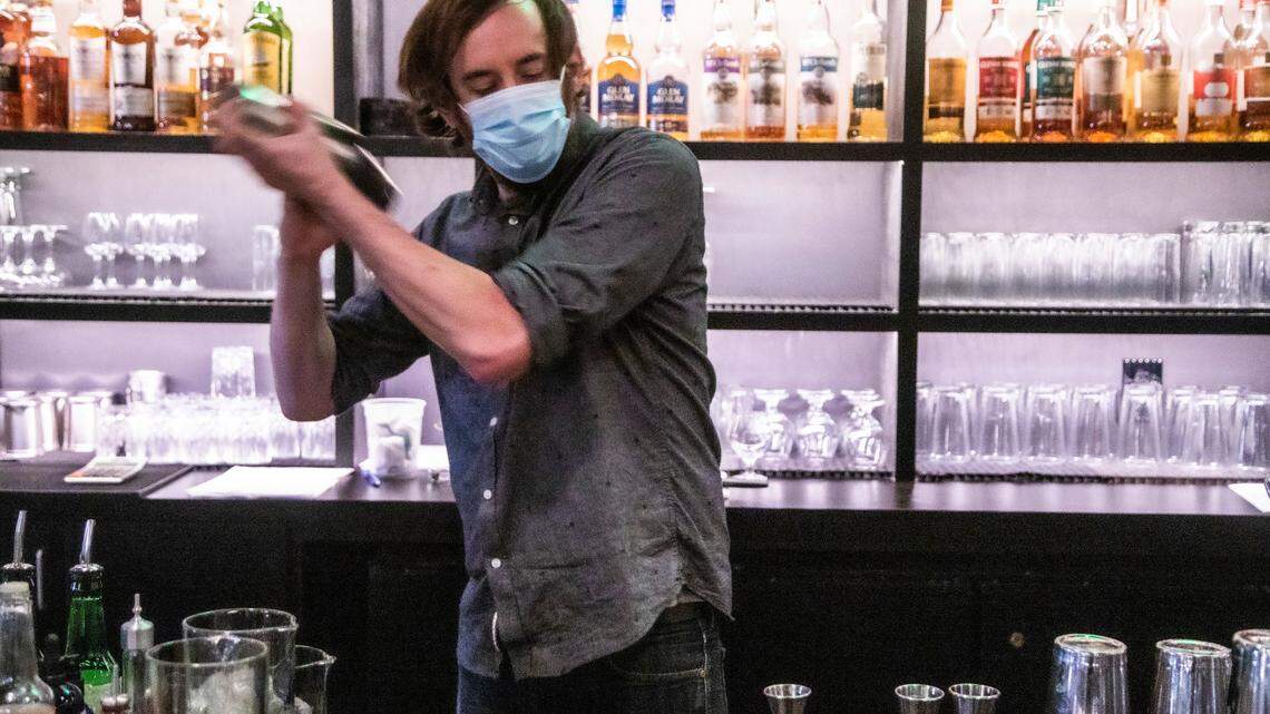 Bartender Lentz Ison mixes a drink at Dram & Draught in Raleigh Friday night, Oct. 2, 2020. The state moved into Phase 3 of its reopening plan Friday at 5 p.m., meaning private bars could open at 30 percent of their outdoor capacity.