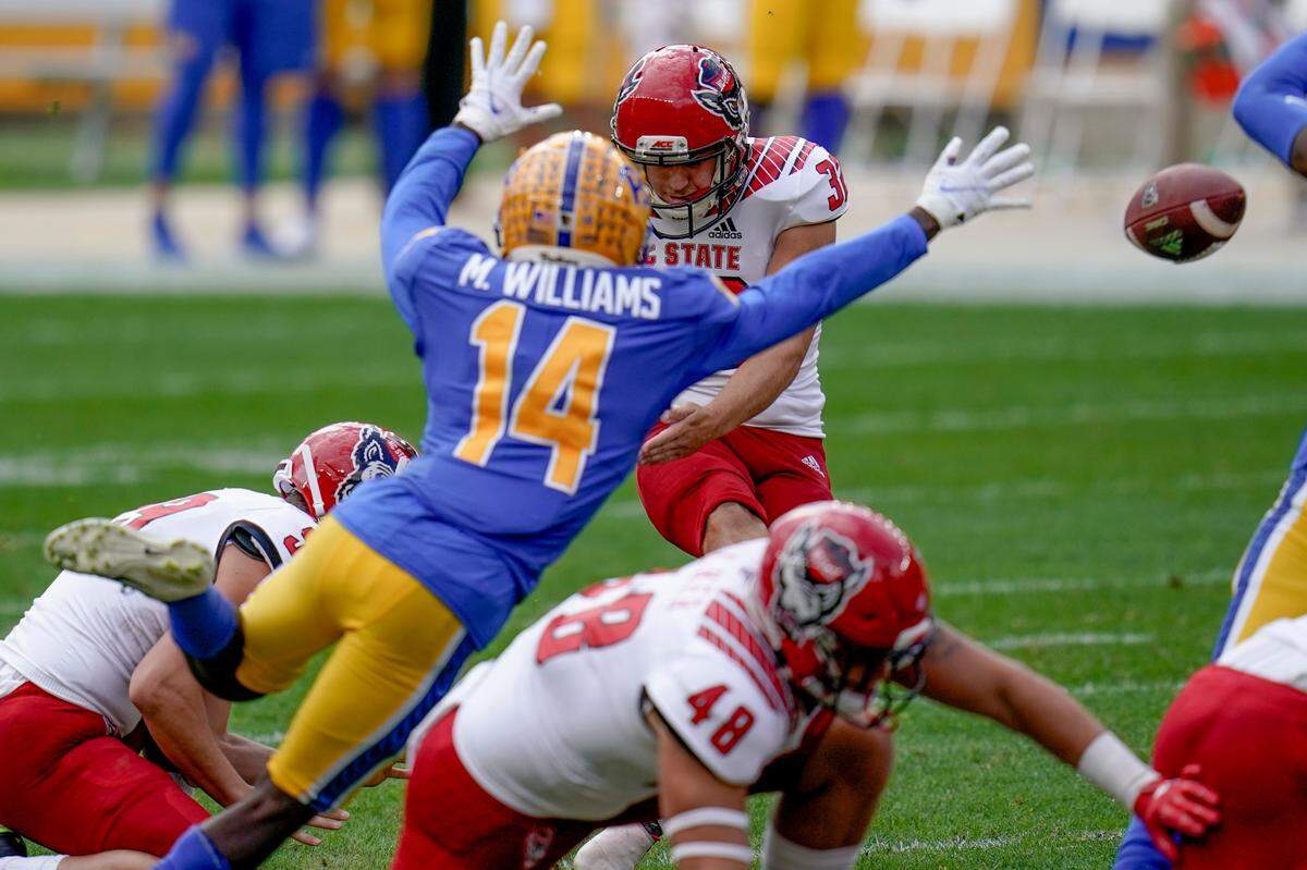 North Carolina State place kicker Christopher Dunn (32) makes a field goal as Pittsburgh Panthers defensive back Marquis Williams (14) defends during an NCAA college football game, Saturday, Oct. 3, 2020, in Pittsburgh.