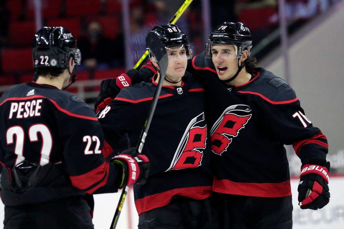 Carolina Hurricanes’ Martin Necas (88) celebrates his goal with tammates Brett Pesce (22) and Brady Skjei (76) during the second period of an NHL hockey game against the Detroit Red Wings in Raleigh, N.C., Thursday, March 4, 2021. AP Photo/Chris Seward)