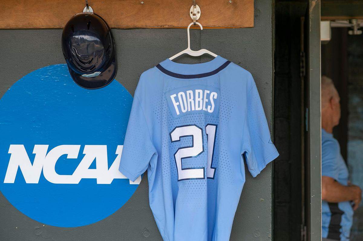 The uniform of North Carolina head coach Scott Forbes (21) hangs in the Tar Heels’ dugout during their NCAA regional elimination game against Georgia on Sunday, June 5, 2022 at Boshamer Stadium in Chapel Hill, N.C.  Forbes was suspended for two games by umpires on Saturday when he protested a call during a game against VCU. 