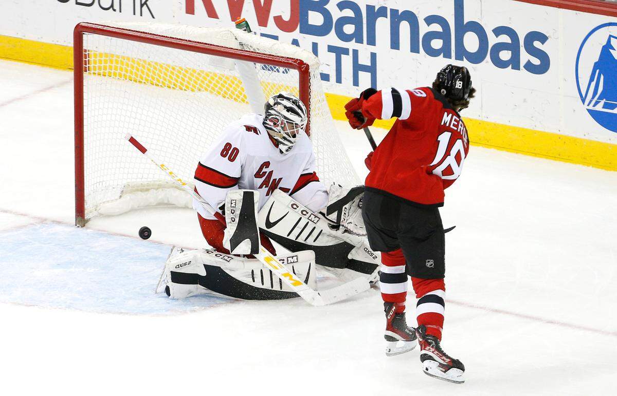New Jersey Devils center Dawson Mercer (18) misses a shot at the goal against Carolina Hurricanes goaltender Jack LaFontaine (80) during the third period of an NHL hockey game, Saturday, Jan. 22, 2022, in Newark, N.J. (AP Photo/Noah K. Murray)