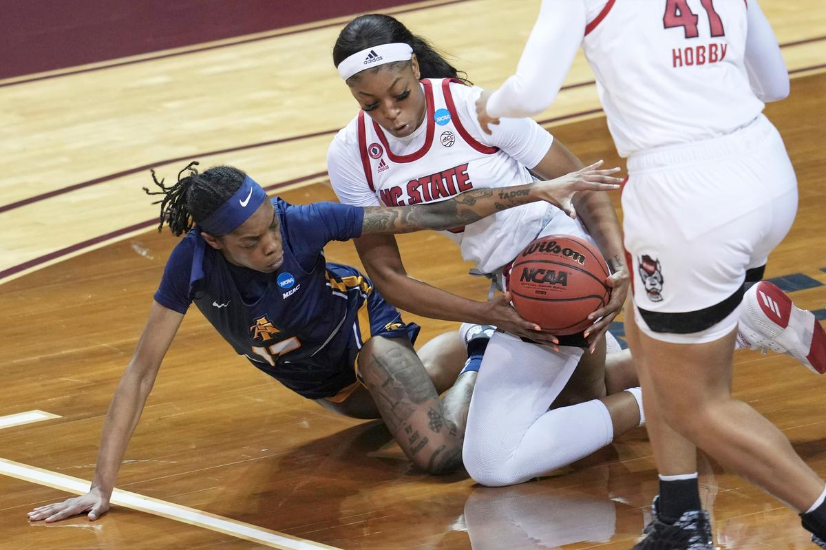 North Carolina A&T’s Deja Winters, left, and North Carolina State’s Jada Boyd, right, battle for a loose ball during the first half of a college basketball game in the first round of the women’s NCAA tournament at the University Events Center in San Marcos, Texas, Sunday, March 21, 2021. (AP Photo/Chuck Burton)