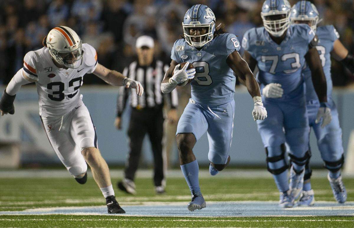 North Carolina’s Michael Carter (8) rushes for 19 yards in the fourth quarter before being stopped by Virginia’s Jaylon Baker (39) in the fourth quarter on Saturday, November 2, 2019 at Kenan Stadium in Chapel Hill, N.C.