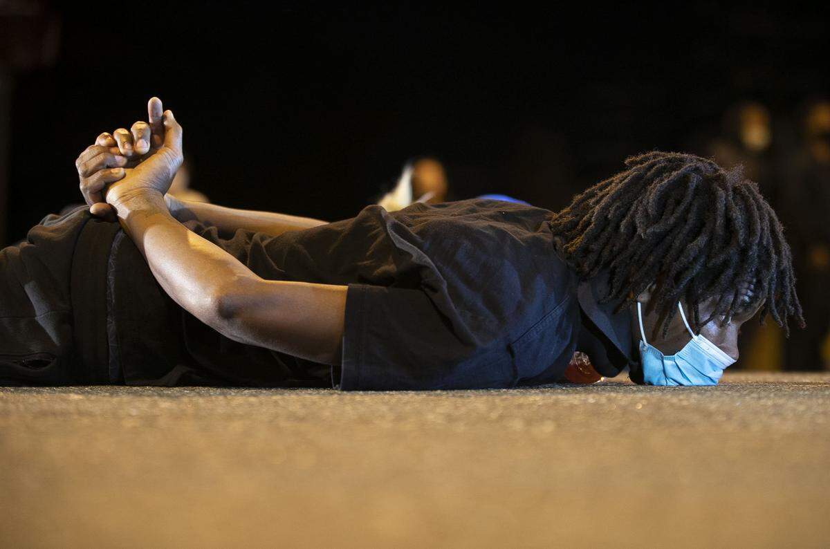 Gregory White of Durham, N.C. lies in the middle of N Duke Street in downtown Durham just after 11 p.m. on Monday, June1, 2020, as he joins other protestors blocking the road in honor of George Floyd, the Minnesota man that died in police custody last week.