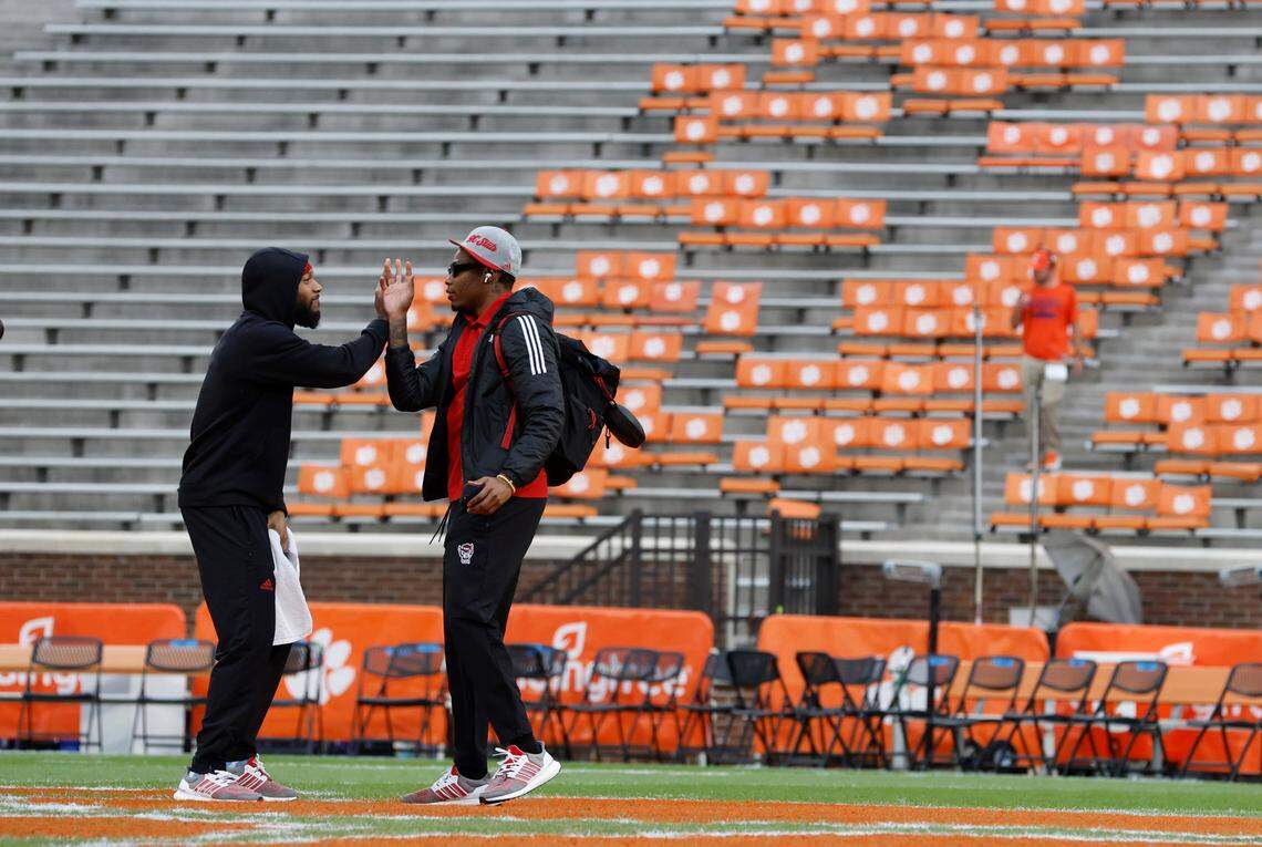 N.C. State’s Derrek Pitts Jr., left, greets Cyrus Fagan as they walk the field before N.C. State’s game against Clemson at Memorial Stadium in Clemson, S.C., Saturday, Oct. 1, 2022. Pitts was the first player on the field, going right from Wolfpack bus to the field.