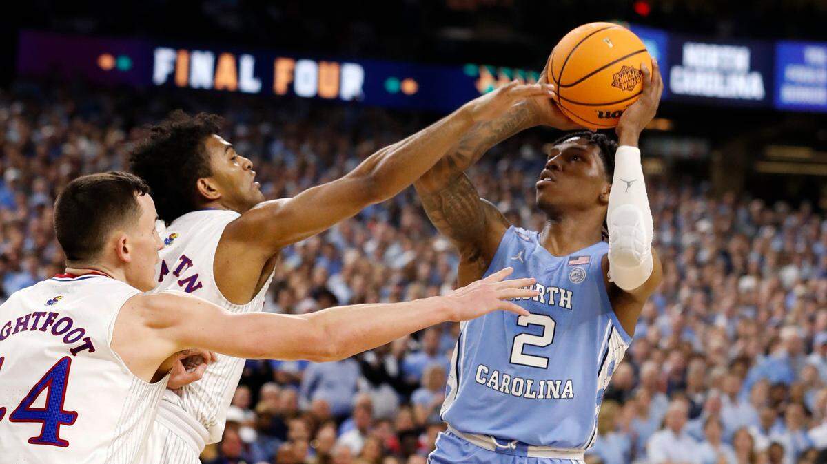North Carolina’s Caleb Love (2) shoots as Kansas’ Remy Martin (11) defends during the first half of UNCís game against Kansas in the NCAA Menís National Championship at the Caesars Superdome in New Orleans, La., Monday, April 4, 2022.