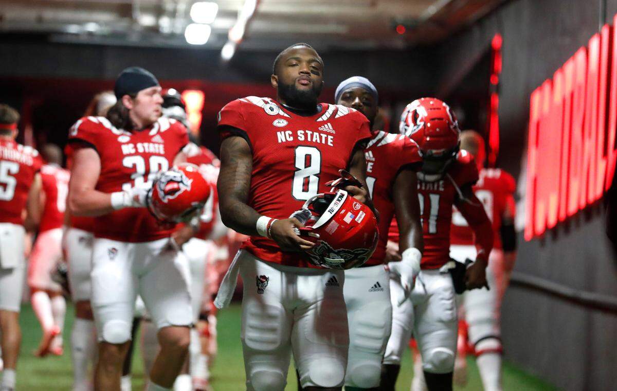 N.C. State running back Ricky Person Jr. (8) and teammates head to the field to warmup before N.C. State’s game against Liberty at Carter-Finley Stadium in Raleigh, N.C., Saturday, Nov. 21, 2020.