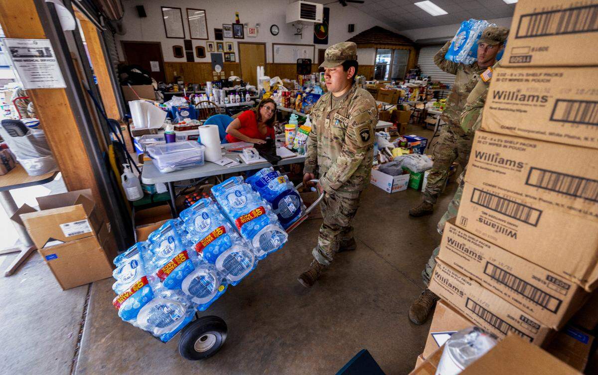 Soldiers with the 101st Airborne Division Air Assault, 2nd Brigade Combat Team, from Fort Campbell, Kentucky, help volunteers distribute water, food, toiletries, and other aid to residents in Maggie Valley on Tuesday, October. 8, 2024. The team has been using the Maggie Valley Pavilion and Town Hall as a distribution base for relief efforts in the town following Tropical Storm Helene.