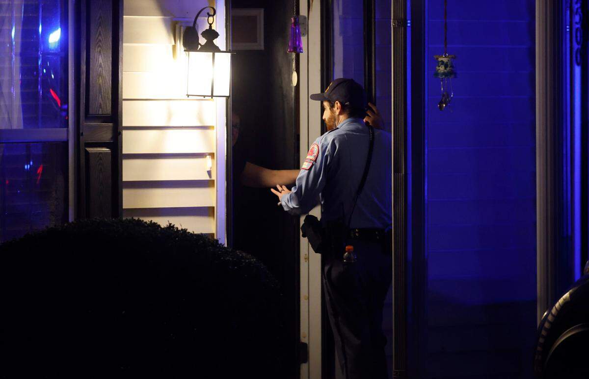 Raleigh police go door to door to ask residents if they are ok and if everyone in their family is accounted for Thursday evening, Oct. 13, 2022, in the Hedingham neighborhood in Raleigh, N.C.