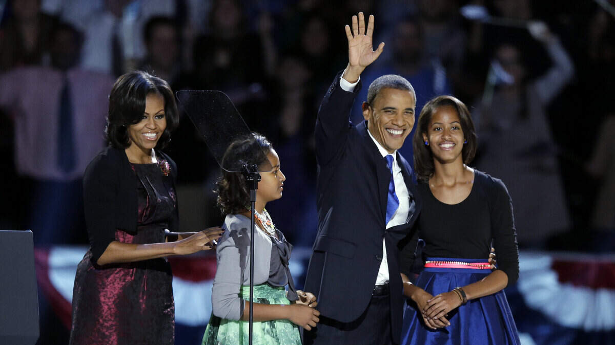 President Barack Obama waves as he walks on stage with first lady Michelle Obama and daughters Malia and Sasha at his election night party Wednesday, Nov. 7, 2012, in Chicago.  (AP Photo/Chris Carlson)