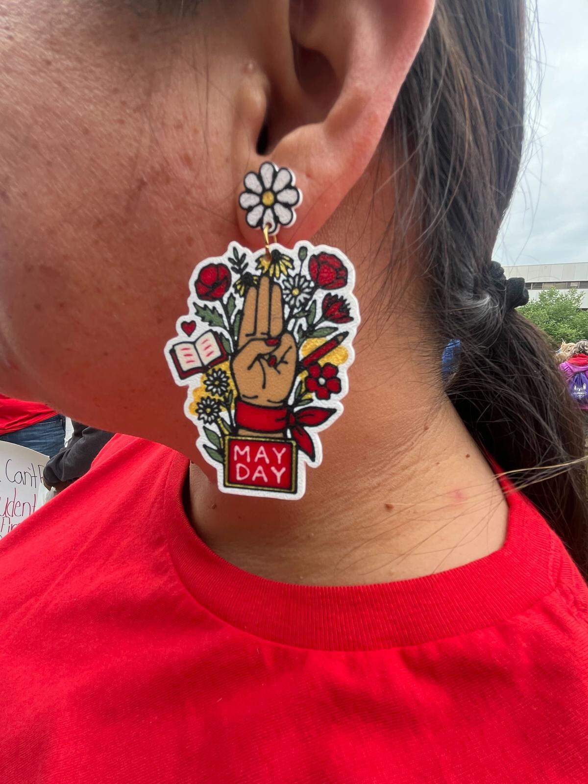 A parent at Carrboro Elementary made May Day earrings for first grade teacher Mayra Menjivar and other staff attending the NCAE protest Friday. Menjivar said while her district gets strong local funding, her and other districts need more funding from the state.