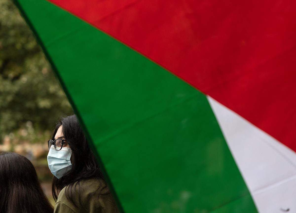 A person stands next to a Palestinian flag during a rally in support of Palestinians at UNC-Chapel Hill on Thursday, Oct. 12, 2023. The rally was organized by the UNC chapter of Students for Justice in Palestine.