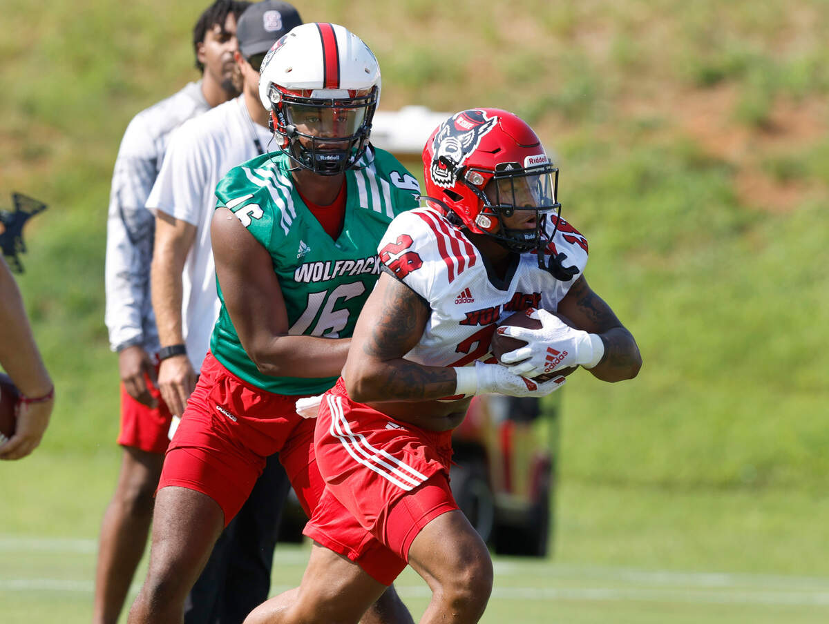 N.C. State quarterback MJ Morris (16) hands the ball off to running back Demarcus Jones II (28) during the Wolfpack’s first practice of fall camp in Raleigh, N.C., Wednesday, August 3, 2022.