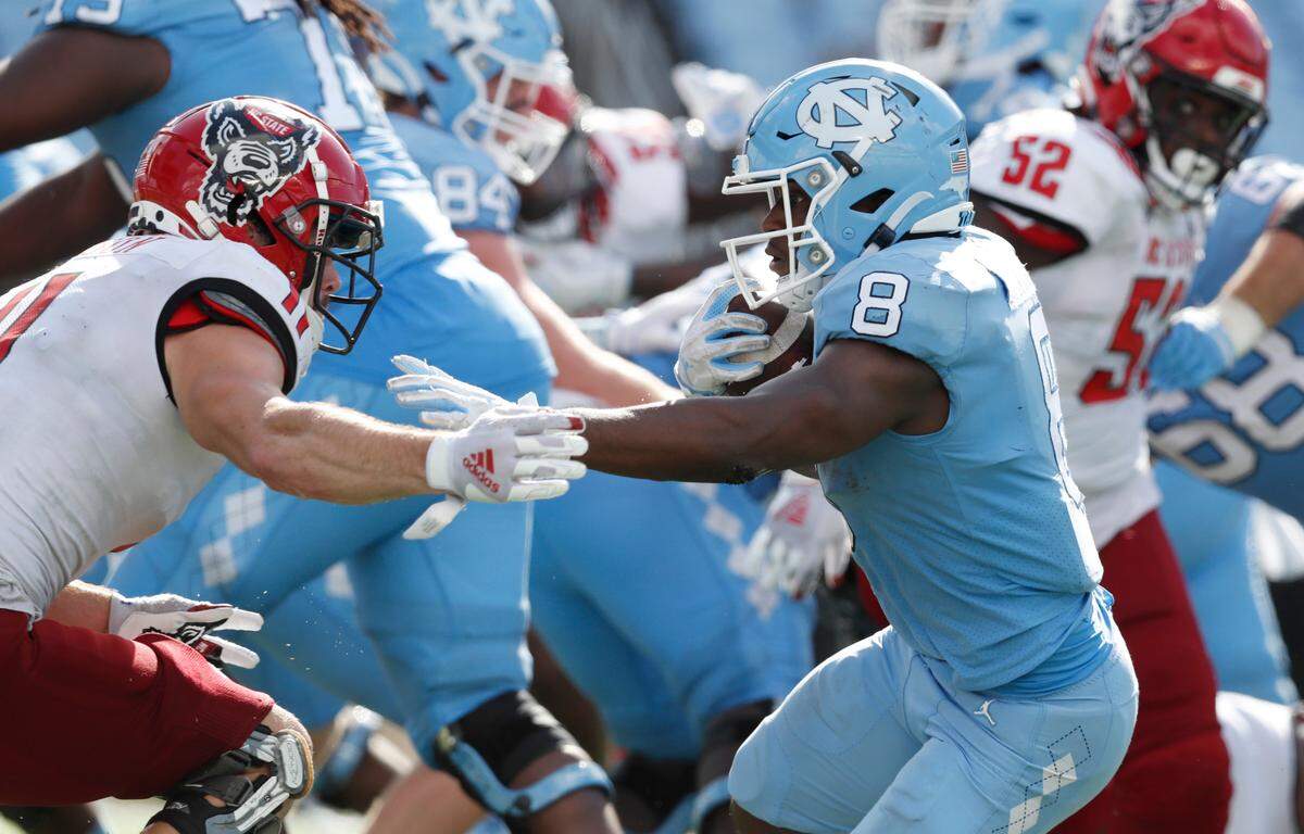 N.C. State linebacker Payton Wilson (11) closes in on North Carolina running back Michael Carter (8) during the second half of UNC’s 48-21 victory over N.C. State at Kenan Stadium in Chapel Hill, N.C., Saturday, Oct. 24, 2020.