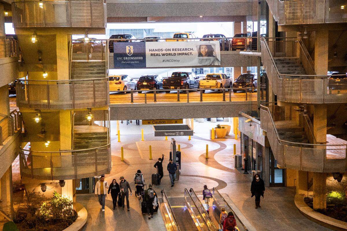 Travelers walk through the parking decks at Raleigh-Durham International Airport in Morrisville Tuesday, Dec. 21, 2021.