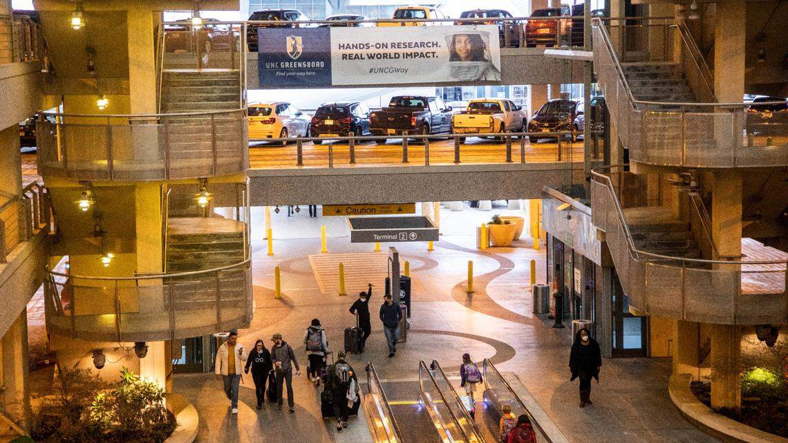 Travelers walk through the parking decks at Raleigh-Durham International Airport in Morrisville on Tuesday, Dec. 21, 2021.