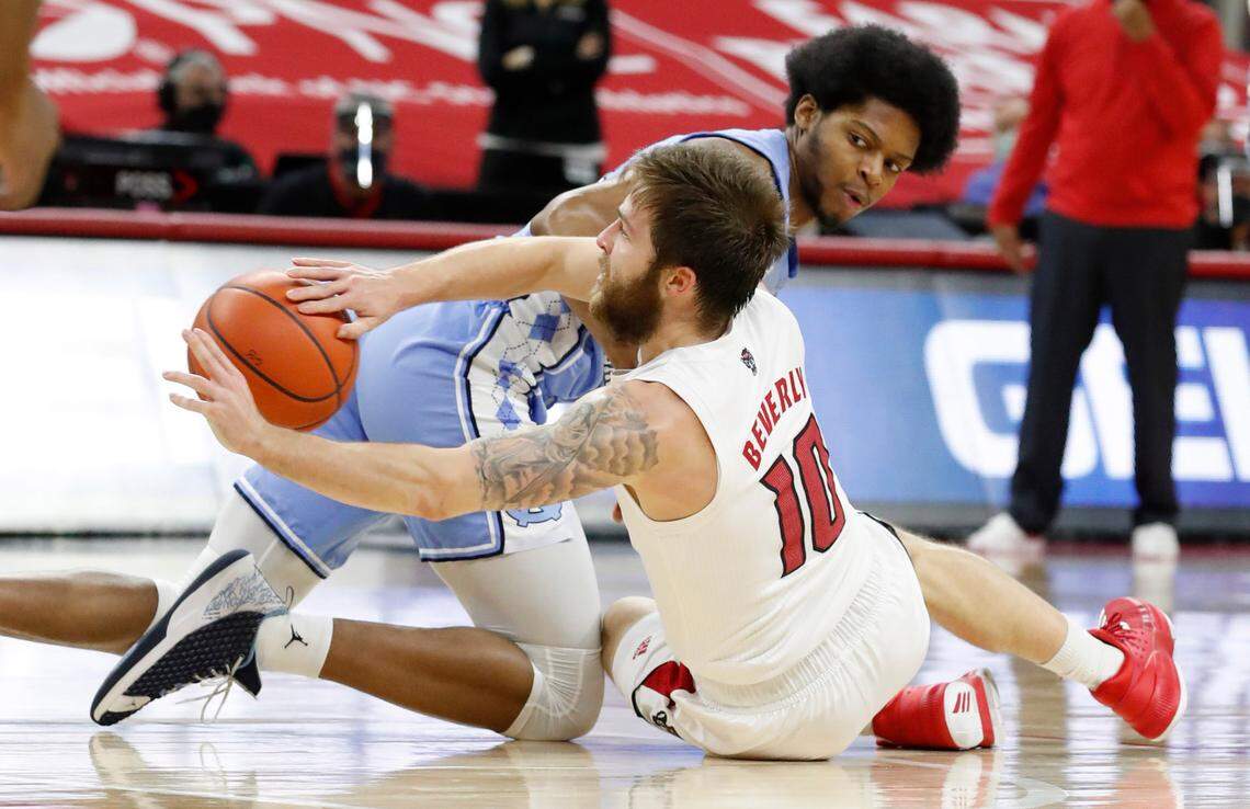 N.C. State’s Braxton Beverly (10) passes away the loose ball as North Carolina’s Kerwin Walton (24) defends during the first half of N.C. State’s game against UNC at PNC Arena in Raleigh, N.C., Tuesday, December 22, 2020.