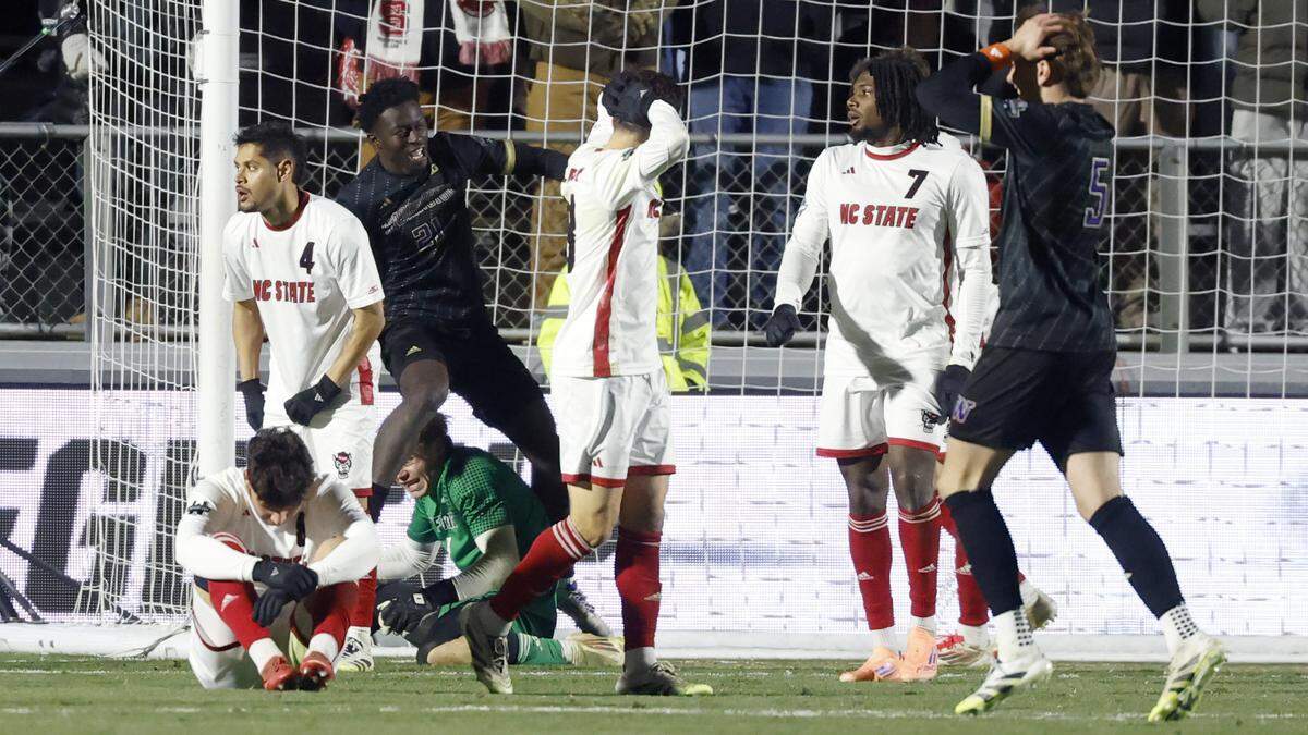 Washington's Osato Enabulele (21) and Asher Hestad (5) celebrate the winning goal by Harrison Bertos in overtime during Washington’s 3-2 victory over N.C. State in the 2025 Men’s Soccer National Championship at WakeMed Soccer Park in Cary, N.C., Monday, Dec. 15, 2025.