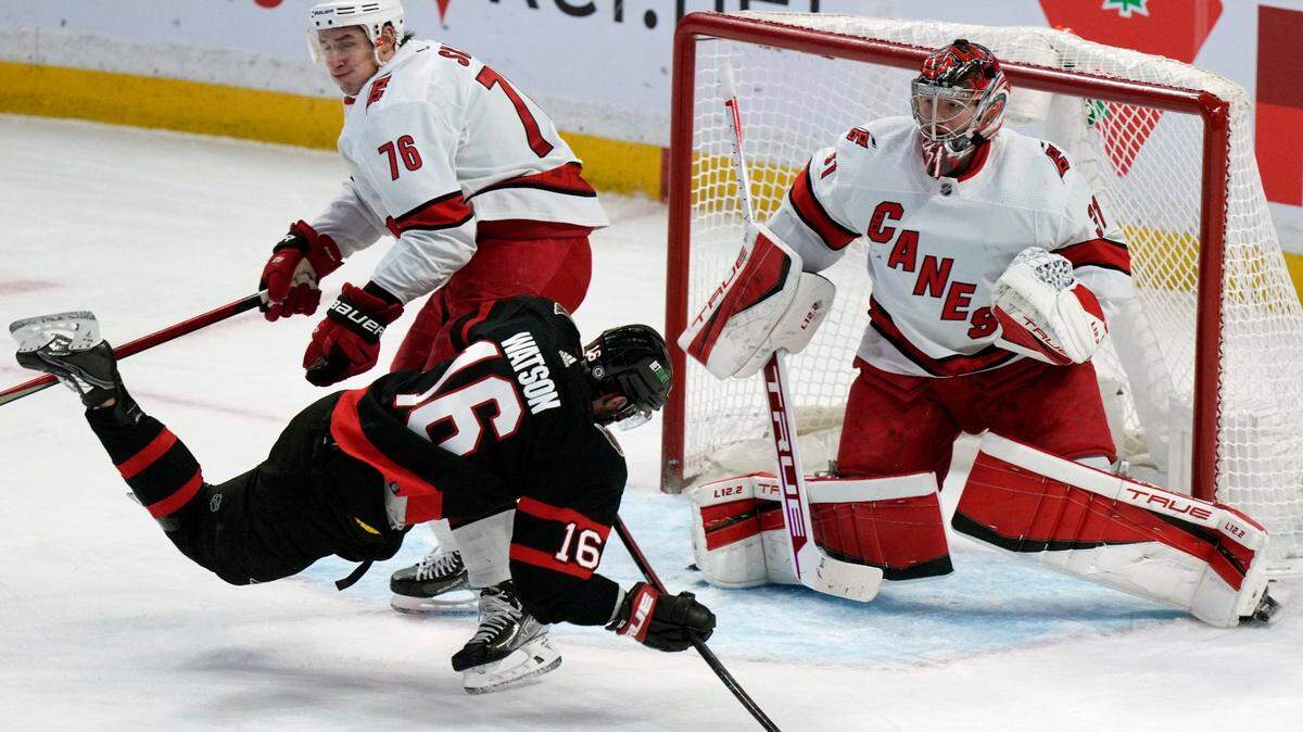 Carolina Hurricanes defenseman Brady Skjei checks Ottawa Senators left wing Austin Watson in front of goaltender Frederik Andersen during the second period of an NHL hockey game, Thursday, Jan. 27, 2022 in Ottawa, Ontario. (Adrian Wyld/The Canadian Press via AP)